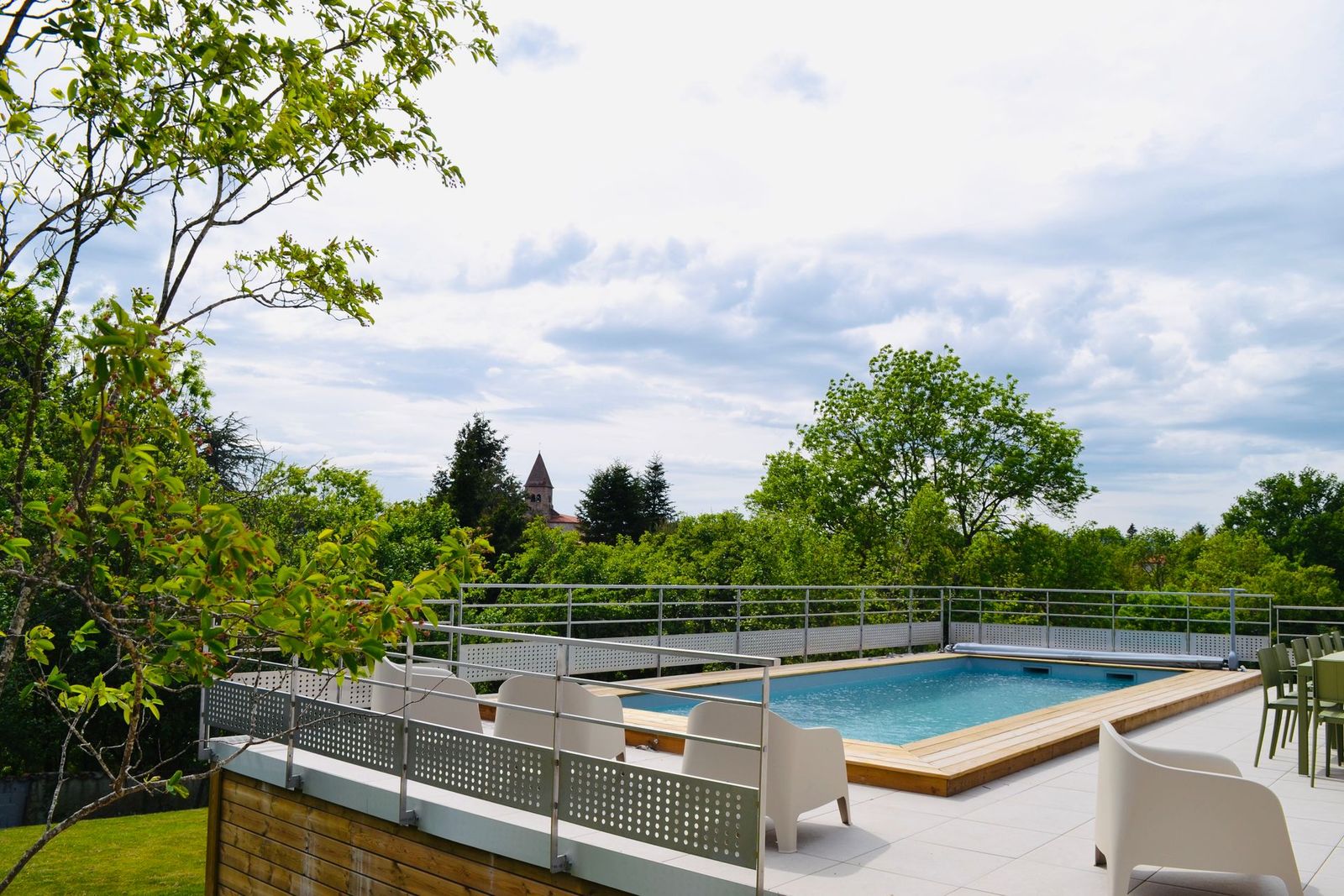 Grande terrasse du Clos Charmette et sa piscine, face au clocher du Prieuré